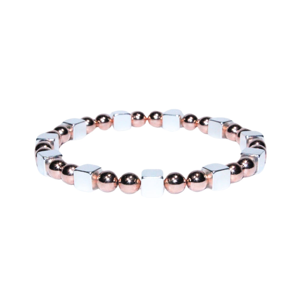 Photo sur fond blanc du bracelet en pierre d'aimant naturelle composé de cubes et de perles argentées et roses.