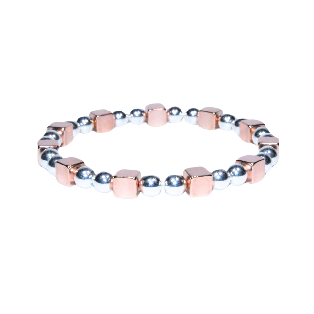 Photo sur fond blanc du bracelet en pierre d'aimant naturelle composé de cubes roses et de perles argentées.