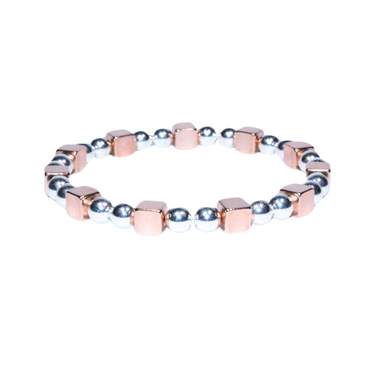 Photo sur fond blanc du bracelet en pierre d'aimant naturelle composé de cubes roses et de perles argentées.