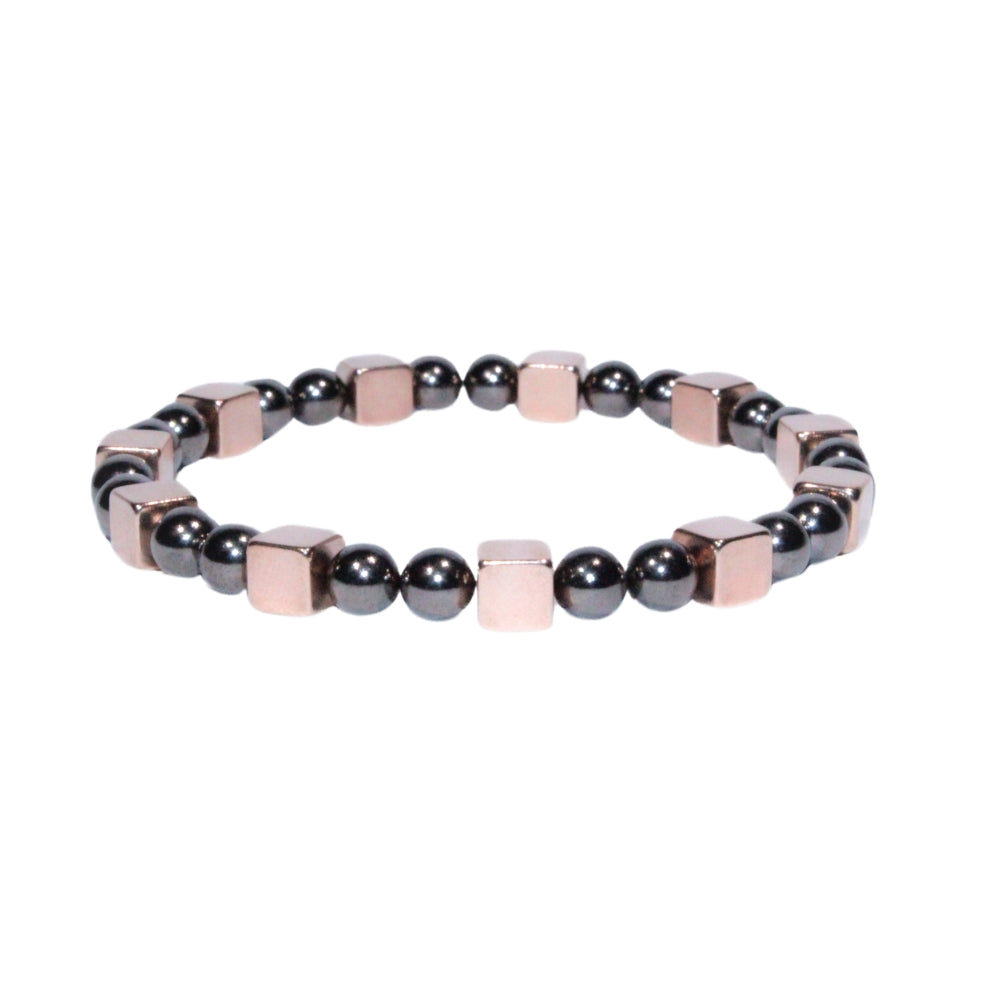 Photo sur fond blanc du bracelet en pierre d'aimant naturelle composé de cubes roses et de perles nacrées.