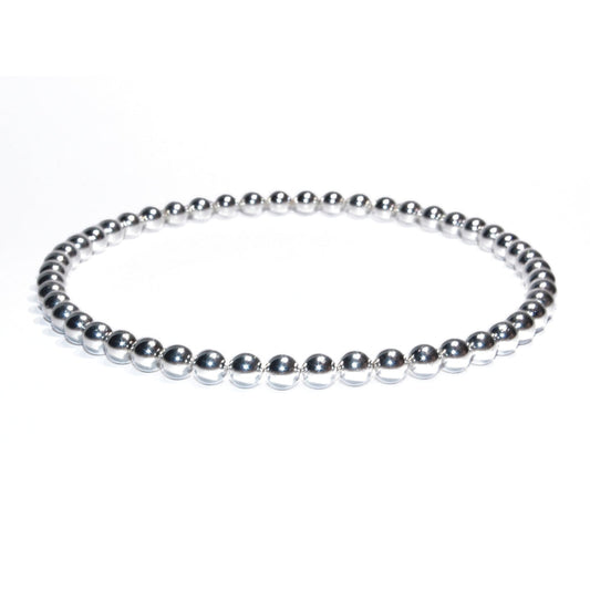 Photo sur fond blanc du bracelet de cheville en pierre d'aimant naturelle composé de perles argentées.