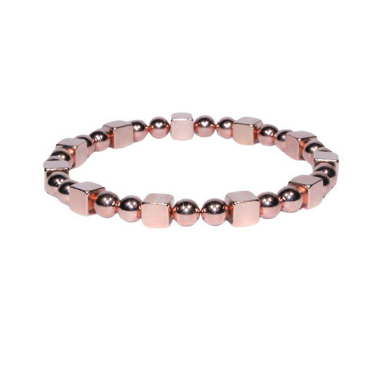 Photo sur fond blanc du bracelet en pierre d'aimant naturelle composé de perles et de cubes de couleur rose.
