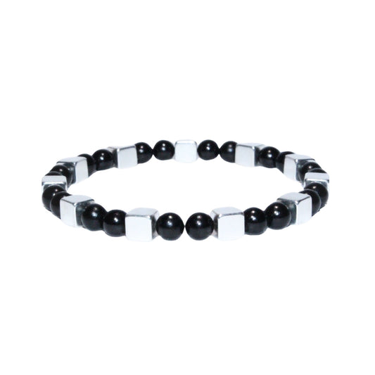 Photo sur fond blanc du bracelet en pierre d'aimant naturelle composé de cubes et de perles argentées et noires.