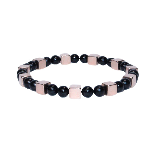 Photo sur fond blanc du bracelet en pierre d'aimant naturelle composé de cubes roses et de perles noires.