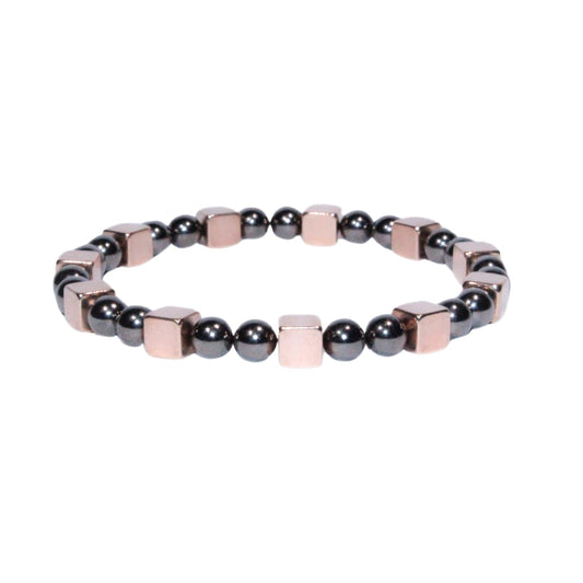 Photo sur fond blanc du bracelet en pierre d'aimant naturelle composé de cubes roses et de perles nacrées.