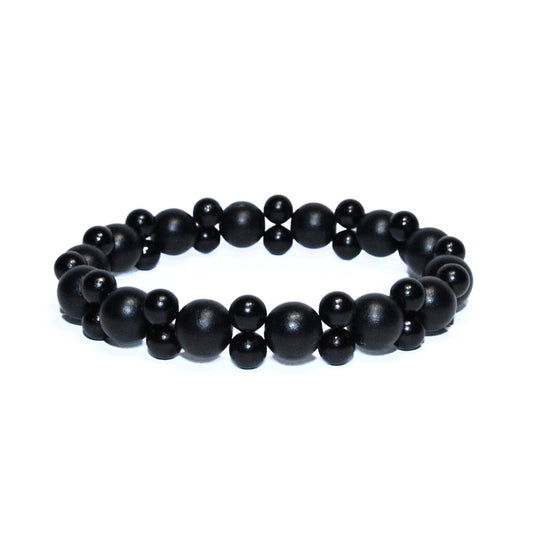 Photo sur fond blanc du bracelet en pierre d'aimant naturelle composé de perles double noires.