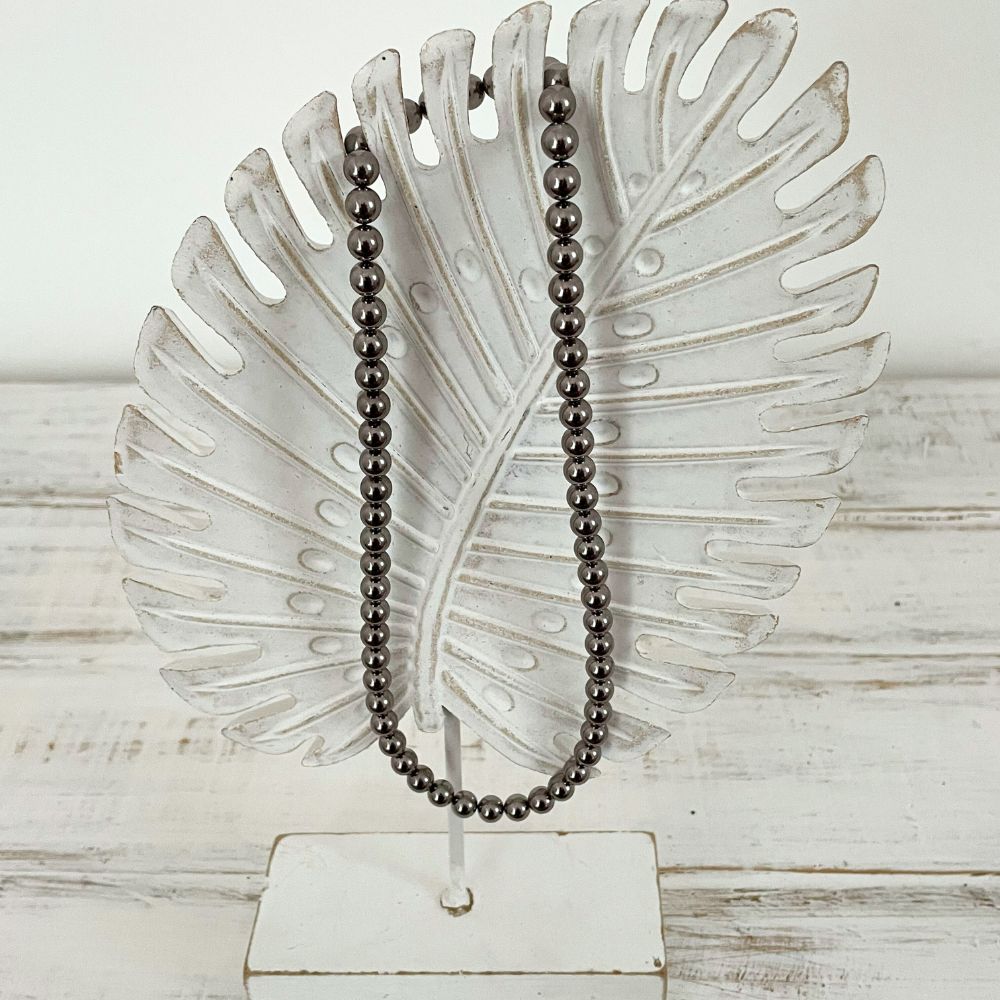 Photo sur fond blanc d'un collier en perles d'aimant pour femme de couleur nacre.