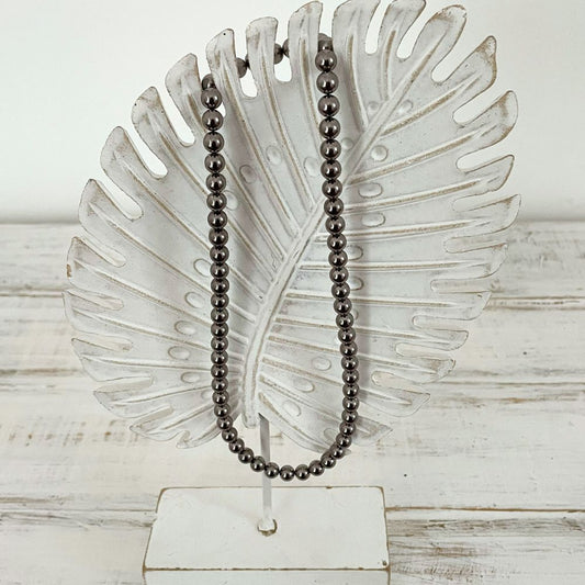 Photo sur fond blanc d'un collier en perles d'aimant pour femme de couleur nacre.